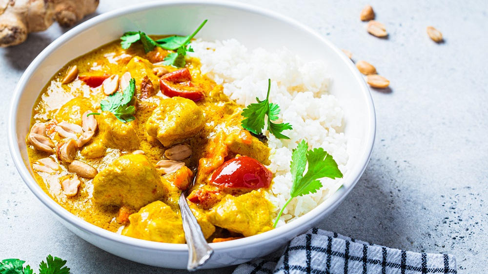 Erdnuss Curry mit Reis in einer Schüssel.