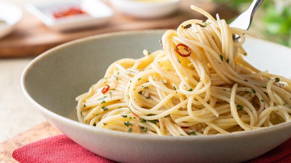 Knoblauch Spaghetti im tiefen Teller und auf Gabel.