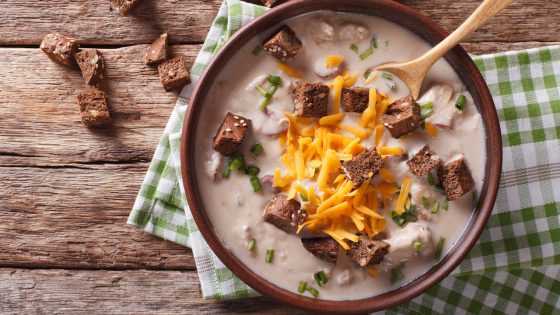 Bavarian beer soup with cheese and bacon close up in a bowl. horizontal top view