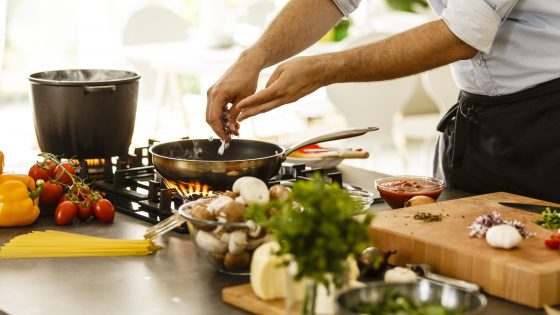Man cooking in the kitchen, preparing pasta, cooking spagheti.