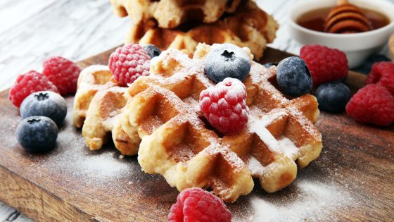 Traditional belgian waffles with fresh blueberries, sugar and raspberries.