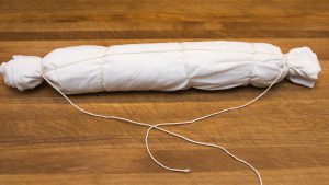 Eine Serviettenknödel eingepackt in einer Serviette mit Zwirn verschlossen