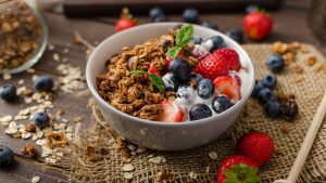 Eine Schüssel mit Joghurt und Früchten zusammen mit einer Portion Granola.