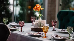 Deko Ideen: Ein liebevoll gedeckter Tisch für 7 Personen, mit gefalteten Servietten und bunten Gläsern