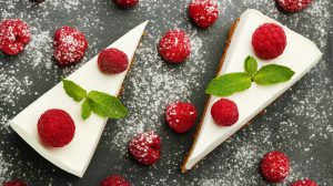 Tasty raspberry cheesecake on grey wooden table