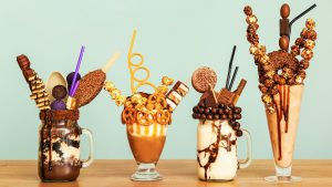 Delicious freak shakes on table against grey background