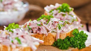 Fleischsalat mit Petersilie auf einer Scheibe Brot