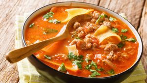 Lasagne-Suppe in einer Schale mit Holzlöffel