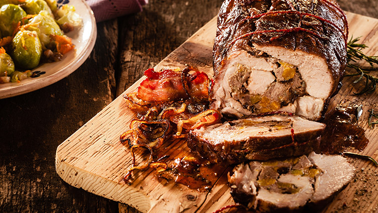 Rollbraten mit Füllung auf Holzbrett