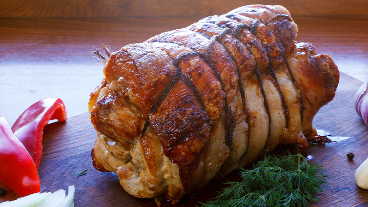Rollbraten auf Holzbrett, gebunden