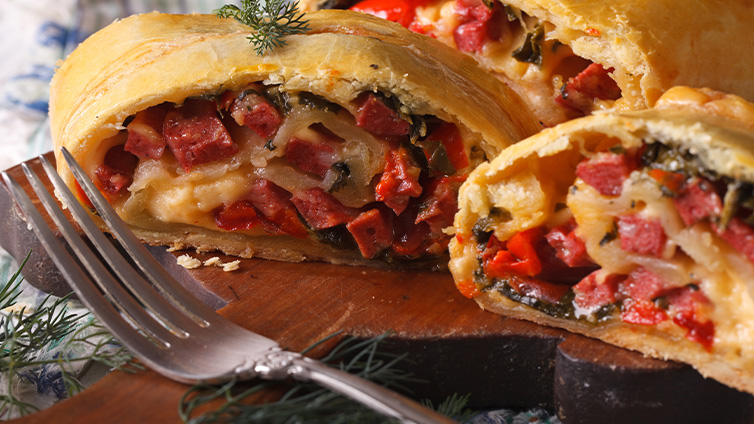 Strudel mit Schinken und Käse auf Schneidebrett