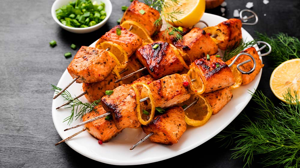 Drinnen grillen: Lachs-Grillspieße mit Zitrone auf Teller