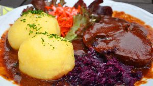 Sauerbraten mit Knödeln auf Teller