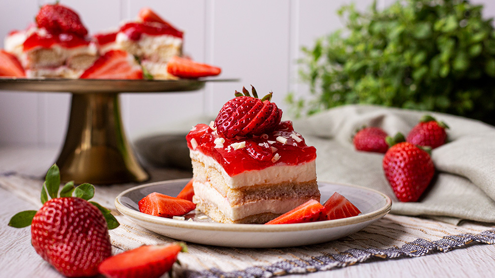 Ein Stück Spaghettieis Kuchen ohne Backen auf einem Teller umgeben von Erdbeeren