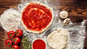 Pizzateig mit Zutaten und Tomatensauce