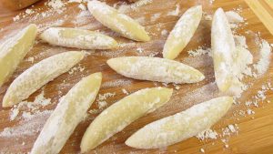 Schupfnudeln auf einem Schneidebrett formen
