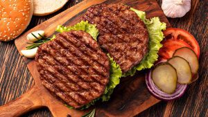 Burgerpatties mit Zutaten auf Brett
