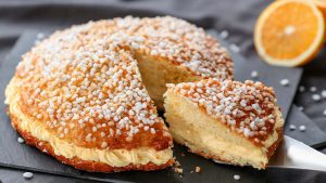 Tarte Tropezienne, angeschnitten mit Orange