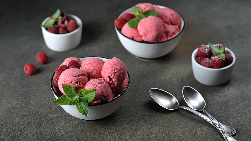 Himbeer-Sorbet in einer Schüssel mit Himbeeren und Minze