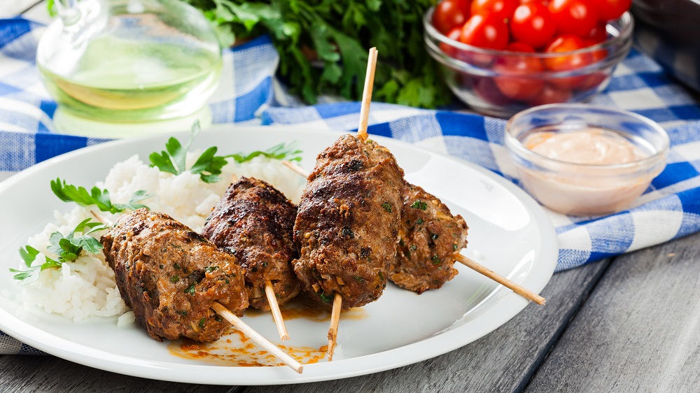 Köfte auf Teller mit Stäbchen und Sauce.