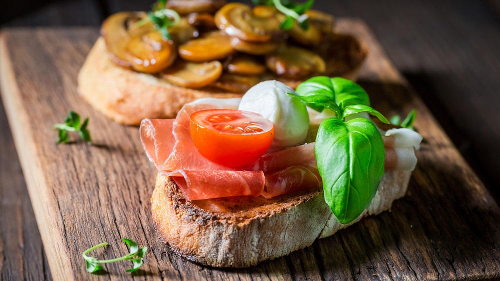 Zwei Crostini auf einem Brett.