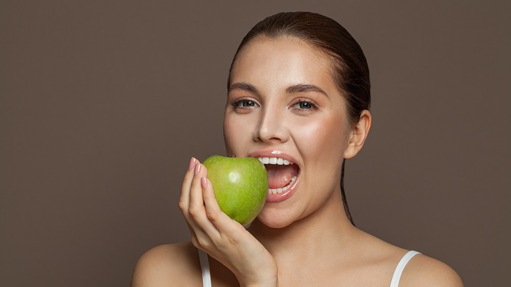 Frau beißt in einen Apfel