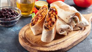 Burritos sind auf einem Brotzeitbrett angerichtet.