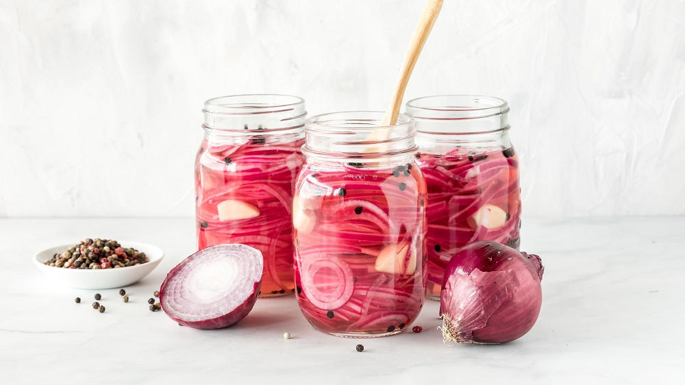 Eingelegte rote Zwiebeln in Gläsern.