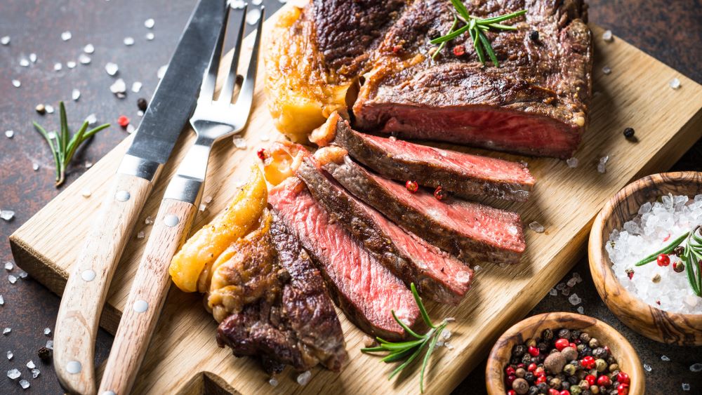 Gebratenes Steak auf einem Holzbrett.