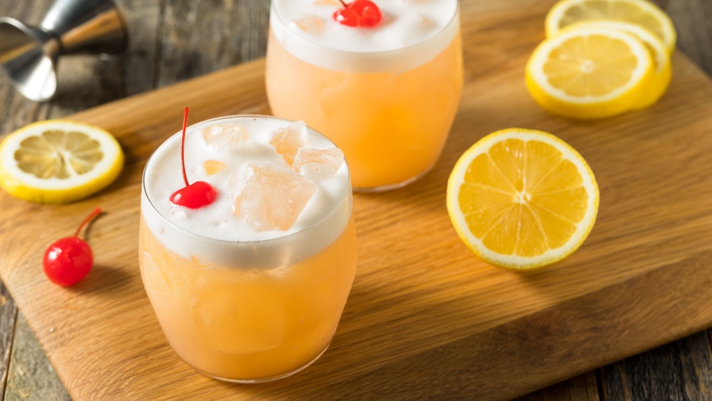 Whisky Sour mit Zutaten in einem Glas.